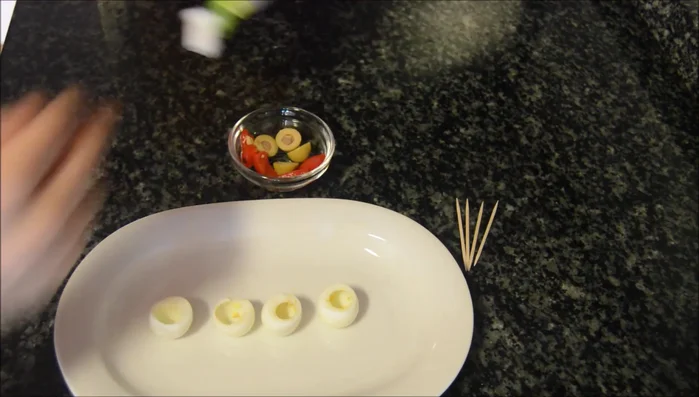 Decorar con aceitunas como sombreritos y pinchar un trozo de pimiento en el centro.