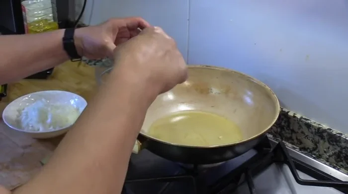 En el mismo wok limpio, calentar aceite de oliva. Sofreír los ajos picados finamente.