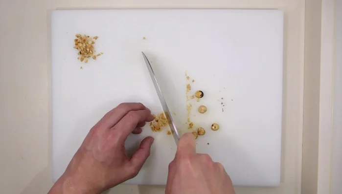 Cortar las avellanas en trocitos pequeños y tostar los piñones en una sartén. Reservar.