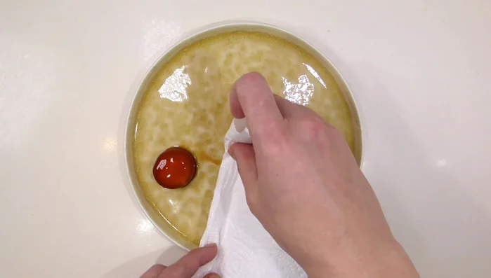 Emplatar: colocar la yema curada, el salmonete, las hierbas frescas, frutos secos y el fondo. Decorar con aceite de avellana.
