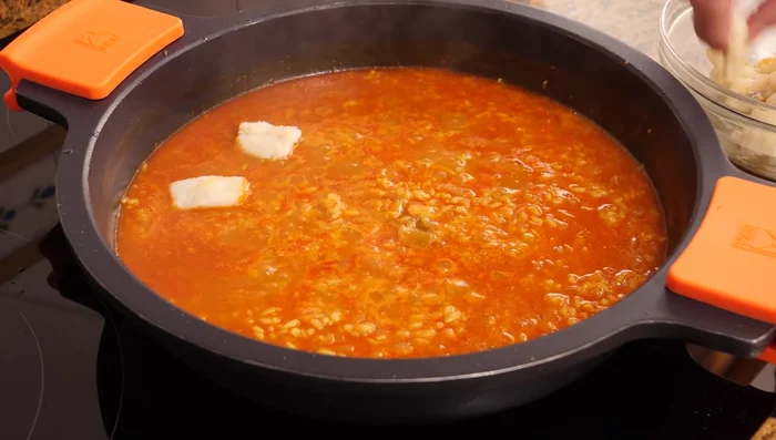 Agregar las migas de bacalao reservadas. Mezclar suavemente con movimientos de vaivén y cocinar 5 minutos más.