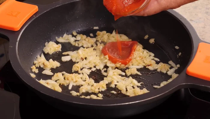 Incorporar la salsa de tomate frito (2 cucharadas), el pimentón dulce/paprika (1 cucharadita), el azafrán molido o colorante alimentario y mezclar bien. Cocinar por 1 minuto.
