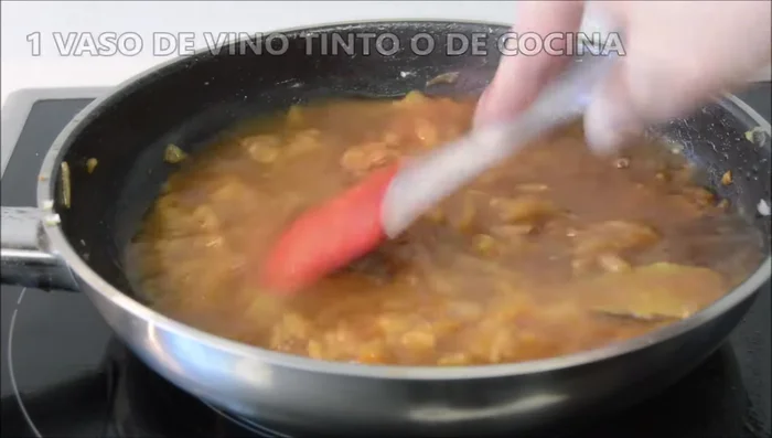 Agregar el vino tinto, mezclar bien y dejar que hierva durante 3-4 minutos hasta que desaparezca el olor a alcohol, removiendo para evitar que se pegue.