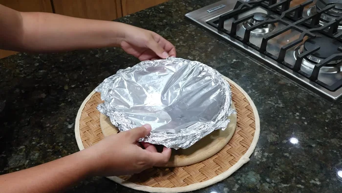 Retirar el papel aluminio. Colocar un plato encima del molde, darle la vuelta con cuidado y retirar el molde.