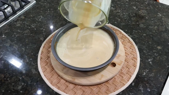 Vaciar la mezcla de galletas licuada sobre el caramelo en el molde.