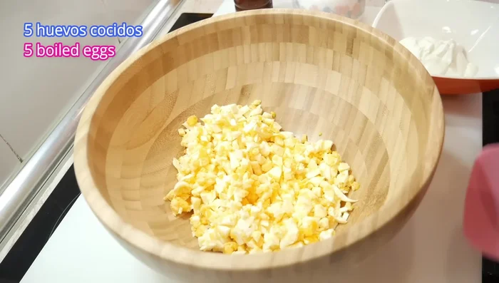 Hervir y cortar 5 huevos en trozos pequeños.