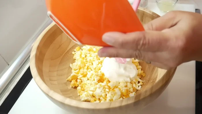 En un bol, mezclar 125g de yogur griego natural sin azúcar con el zumo de medio limón (aproximadamente 2 cucharadas).