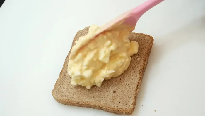 Untar la mezcla de yogur y huevo sobre rebanadas de pan de molde integral.