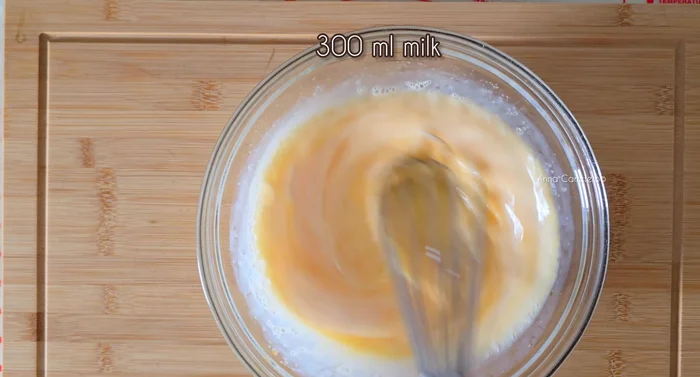 Agregar 300ml de leche a la mezcla de huevos y azúcar.