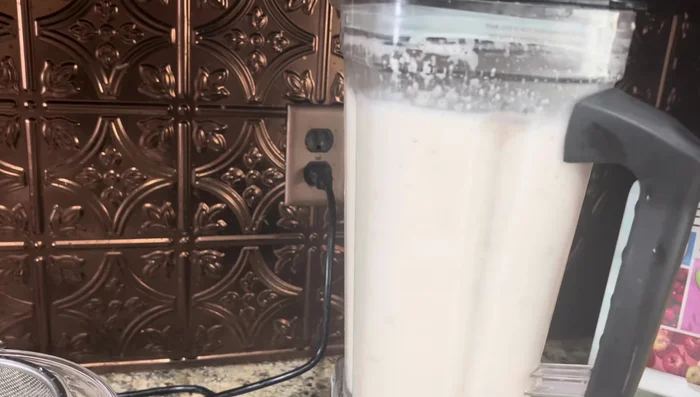 Colar la mezcla para obtener la leche de coco y almendra (273.08). Reservar el coco sólido para usarlo más tarde.