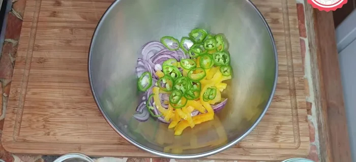 En un bol, mezclar la cebolla, los pimientos, el ajo, el cilantro y el jugo de una lima (ajustar la cantidad de lima según el gusto).