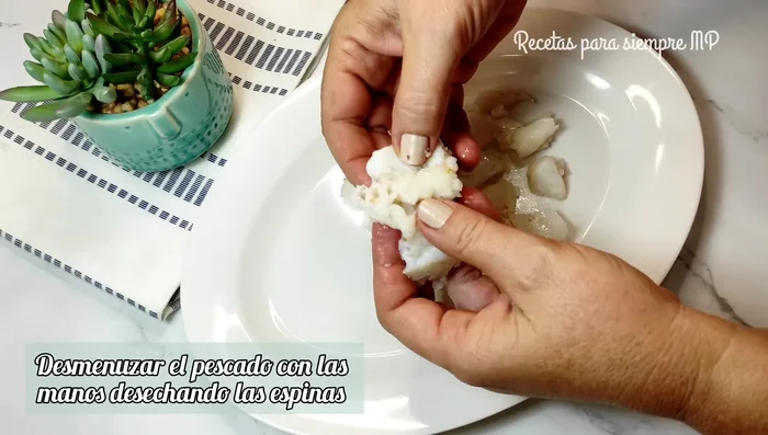 Desmenuzar el pescado enfriado, quitando la piel y las espinas.