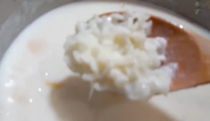 Cuando el arroz esté espesando y cocinándose, retirar la canela en rama y la cáscara de limón.