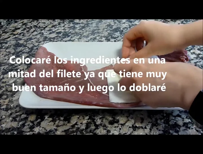Colocar el jamón serrano y el queso en la mitad del filete (72.54).