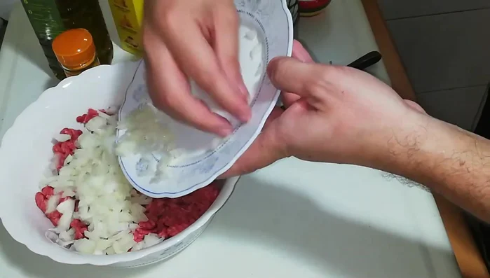 En un bol, mezclar la carne picada, la cebolla picada, la cúrcuma, el eneldo y la sal. Amasar bien.