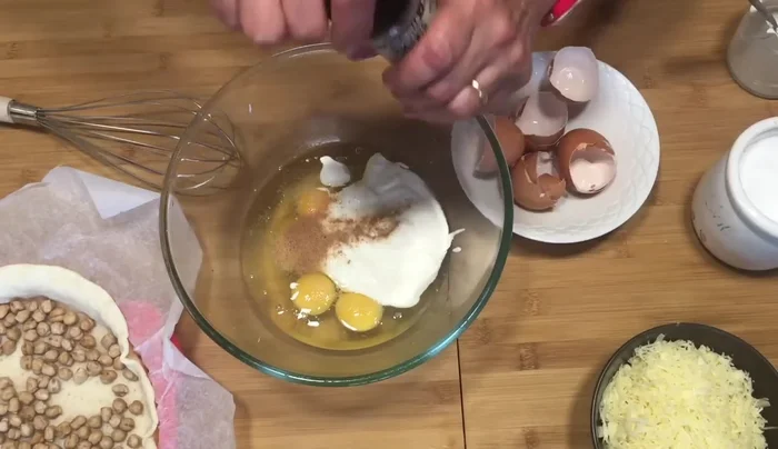 En un recipiente, batir los huevos, la leche, la sal, la nuez moscada y la pimienta negra molida. Agregar el queso rallado y mezclar bien.
