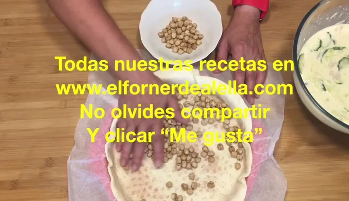Retirar los garbanzos de la base de la quiche y añadir la mezcla de huevos, verduras y gambas, asegurándose de que quede bien distribuida.