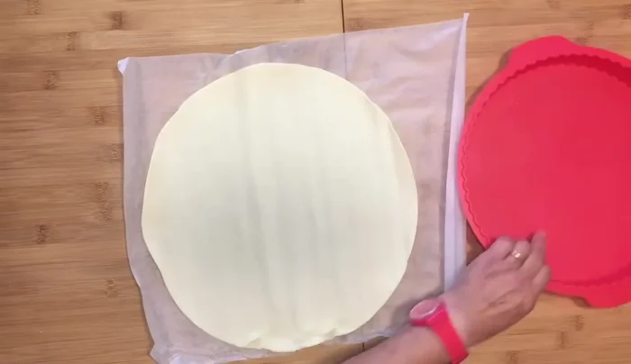 Desenrollar la masa brisa y colocarla en un molde redondo forrado con papel de hornear. Darle forma y asegurar que quede bien adherida a la base y paredes. Pinchar la base con un tenedor para evitar que suba al hornear.