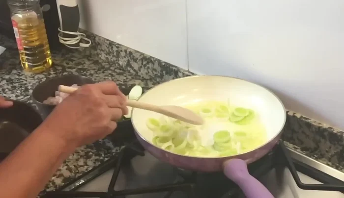 Rehogar los puerros y el calabacín en una sartén con aceite de oliva hasta que estén ligeramente cocidos.