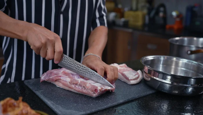 Picar el pellejo y la carne de cerdo en cubos pequeños.
