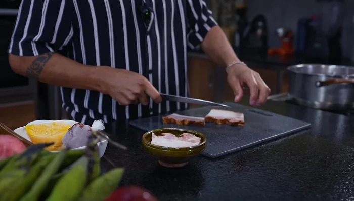 Agregar la carne de cerdo y el pellejo a una olla.
