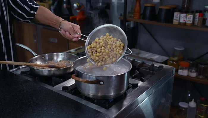 Colar las menestras (garbanzos, frejol, etc.) y agregarlas a la olla con la carne.
