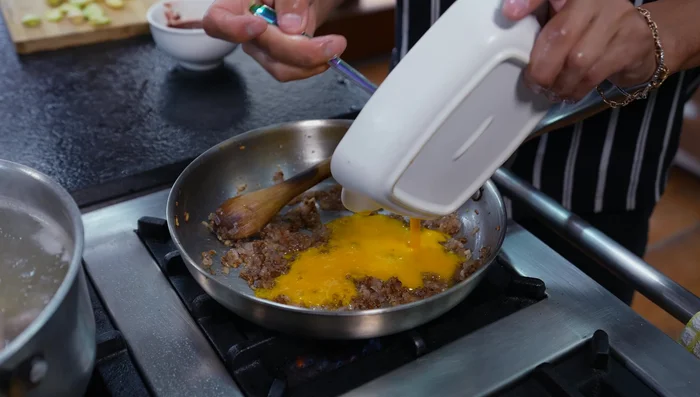 Agregar la pasta de ají amarillo, ají panca, comino, orégano a la olla.
