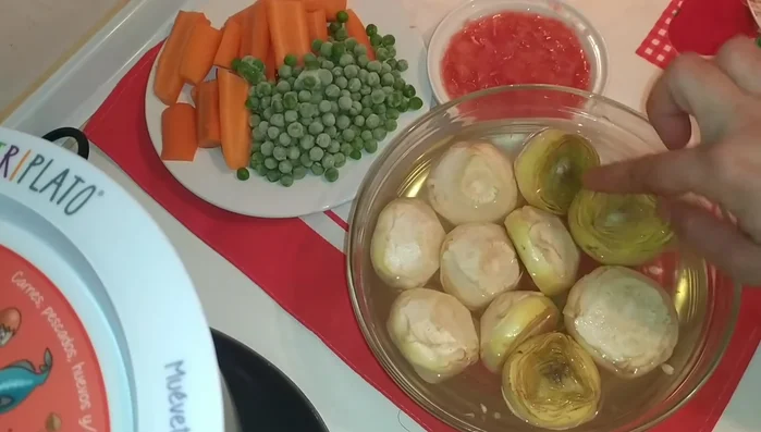 Mientras tanto, preparar las alcachofas: cortarlas y dejarlas en remojo en un bol con agua, sal y limón para evitar que se oxiden. (Cambiar el agua para eliminar el exceso de sal).