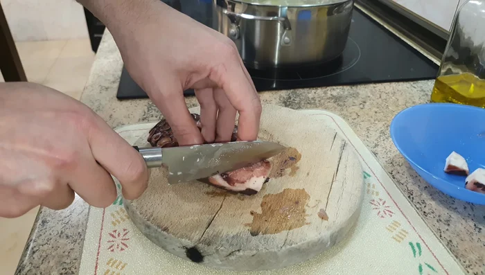Mientras las patatas se cocinan, cortar el pulpo cocido en lonchas finas y ligeramente sesgadas.