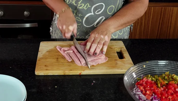 Picar medio kilo de jamón de pavo en cuadritos.