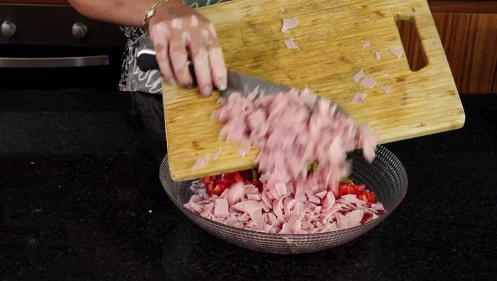 En un recipiente grande, mezclar el jamón, la lechuga desinfectada, la cebolla, los jitomates y los chiles.