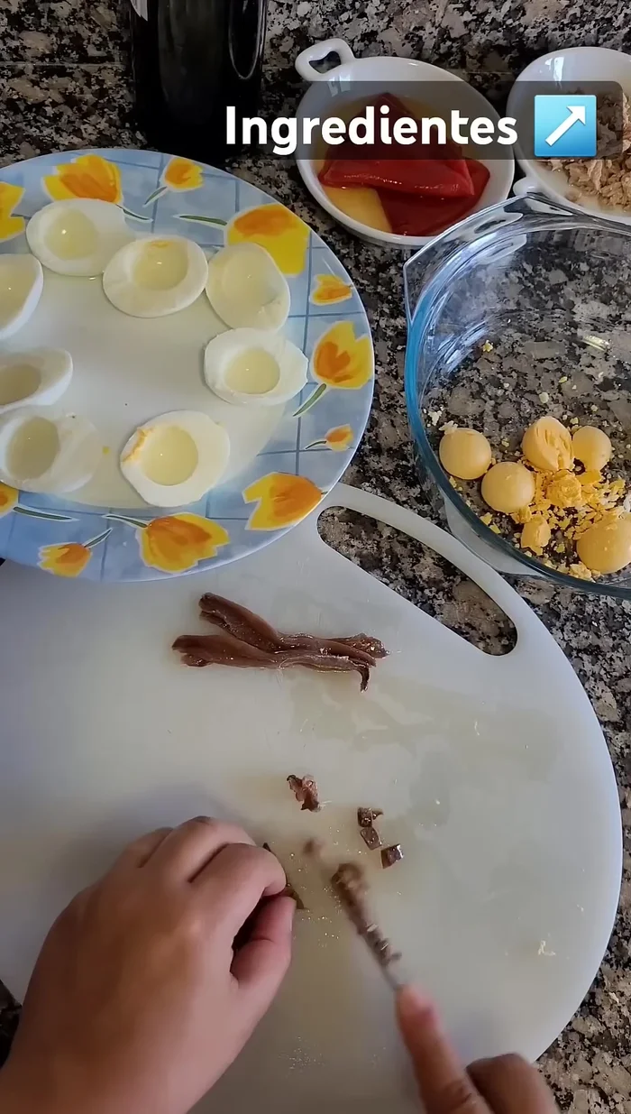 Partir las anchoas en trozos pequeños. Hacer lo mismo con los pimientos del piquillo (cortar en tiras y luego en cuadraditos).