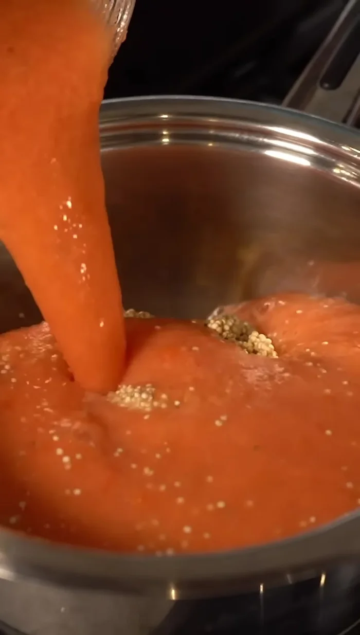 Verter la salsa de tomate sobre la quinoa. La proporción es de 2 partes de líquido por 1 parte de quinoa.