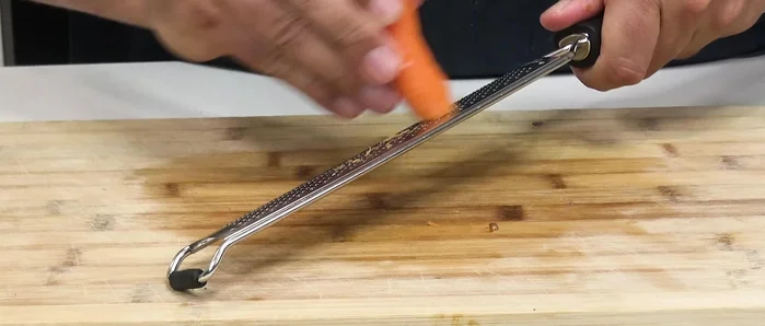 Rallar la zanahoria con piel y añadirla al cuenco.