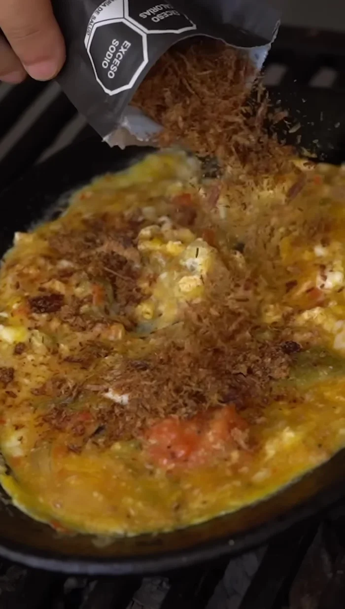 Añadir la machaca a los huevos a media cocción.