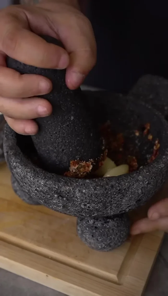 Incorporar la cebolla y el ajo sofritos al molcajete.