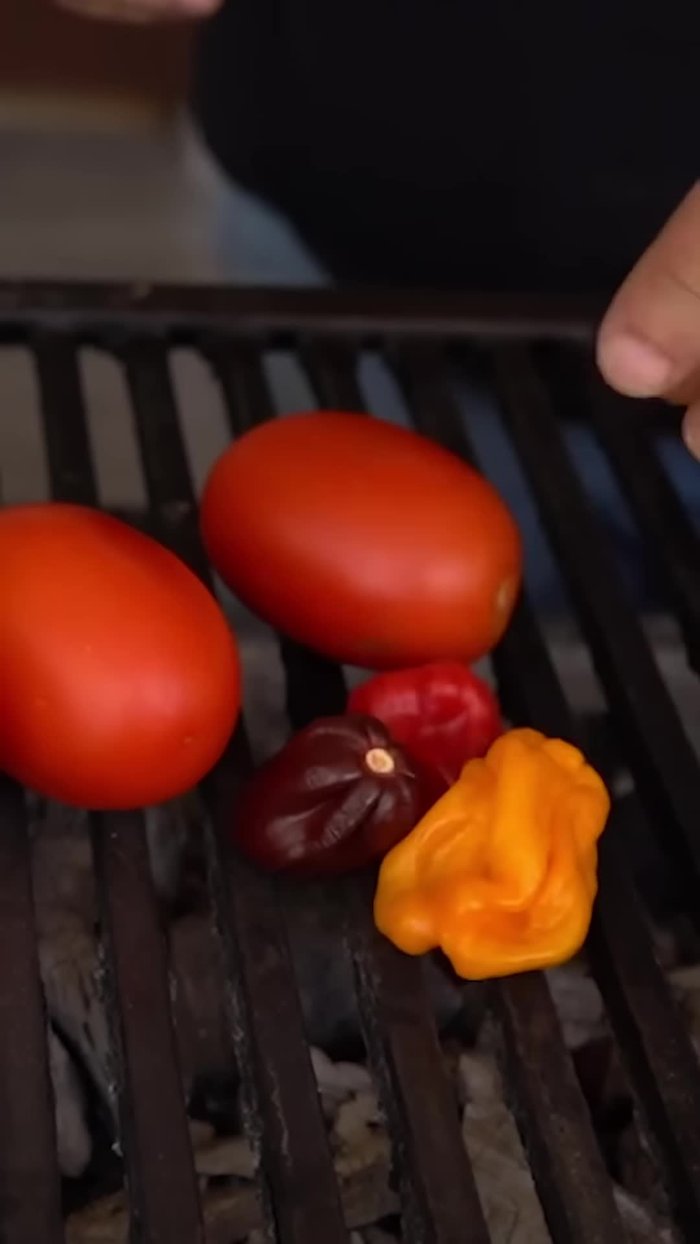 Asar tomates, chiles habaneros, chiles California y un tomatillo.