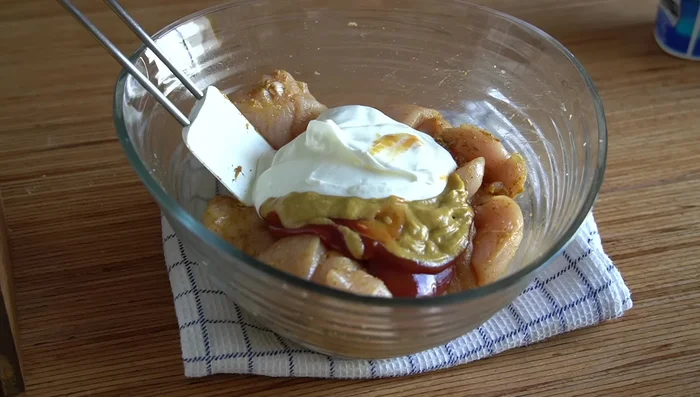 Añadir el ketchup, la mostaza y el yogur griego. Mezclar todo y tapar con film transparente. Marinar al menos una hora (idealmente, de un día para otro en la nevera).