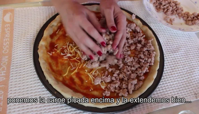 Extender la carne picada sobre el queso, cubriendo toda la superficie. (76.08)