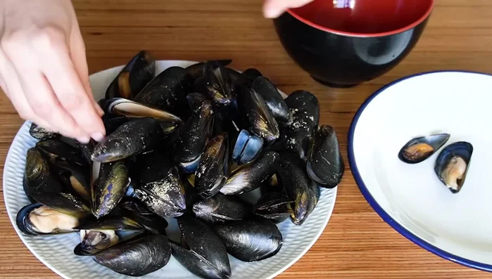 Separar las conchas de algunos mejillones. Añadir el ajo machacado con perejil, un chorrito de vino blanco y el caldo colado de los mejillones a la sartén. Agregar agua hasta obtener 1 litro y medio.