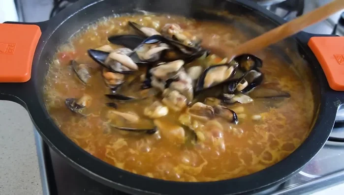 Añadir los mejillones, mezclar y apagar el fuego. Dejar reposar unos 3 minutos.