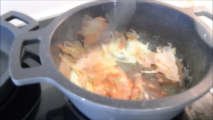 Incorporar las cabezas y pieles de las gambas (y opcionalmente, una ramita de perejil) al fumet. Cocinar un minuto.