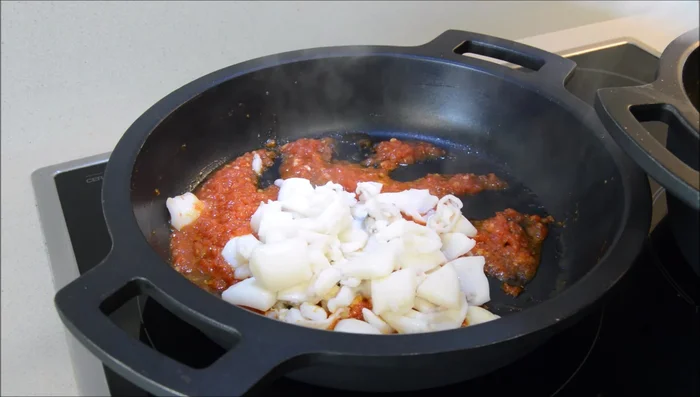 Añadir la sepia salteada a la salsa de tomate y cocinar un minuto.