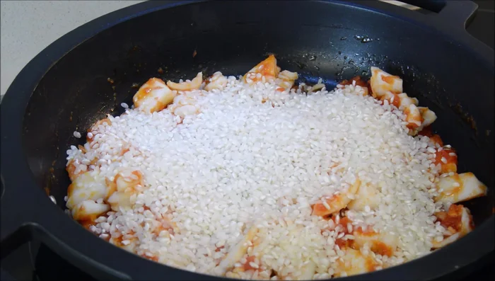 Incorporar el arroz, sal, pimentón dulce y el sofrito. Saltear un par de minutos.