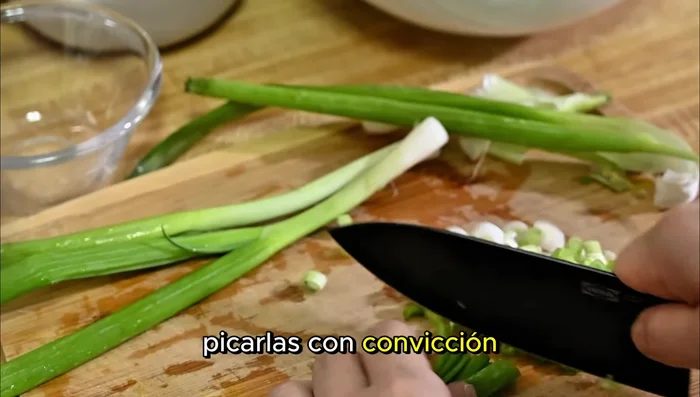 Picar finamente las cebollas verdes. (Casi como una declaración de principios, según el narrador)