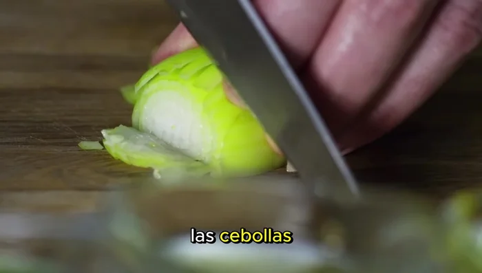 Calentar el aceite en una sartén a fuego medio. Añadir las cebollas verdes picadas y sofreír hasta que estén ligeramente doradas.