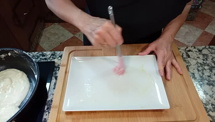 Extender un poco de aceite en un plato para evitar que la bechamel se pegue. Colocar cucharadas de bechamel, partir los huevos por la mitad y colocarlos encima, cubriendo con más bechamel.