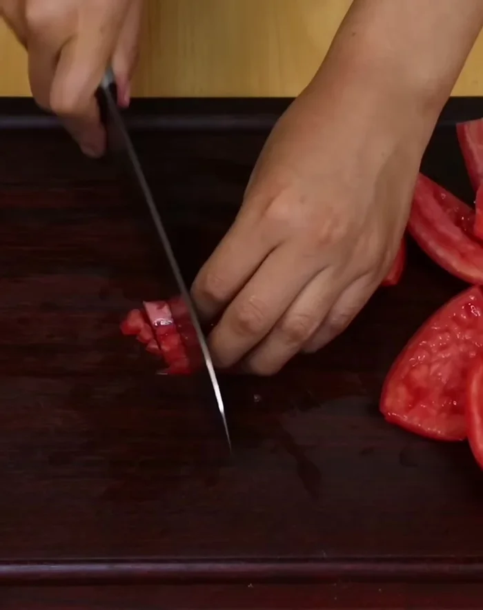 Cortar un tomate en tiras medianas y luego en cubos.