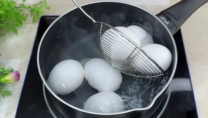 Cocer los huevos en agua con sal y vinagre durante 10 minutos. Luego, enfriarlos en agua con hielo.