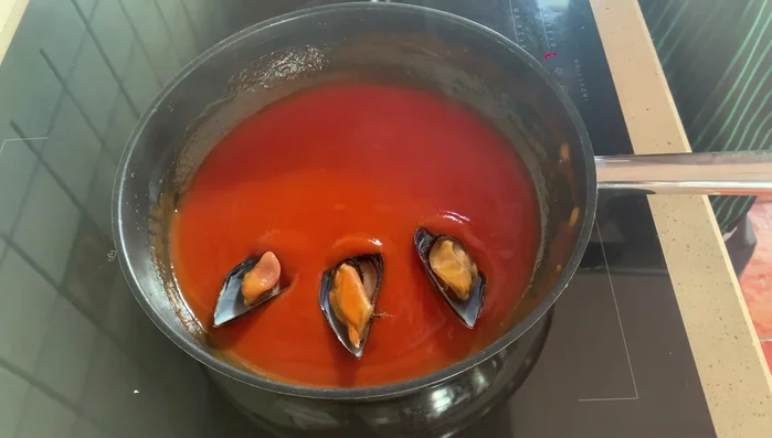 Mezclar suavemente para que la salsa cubra los mejillones.